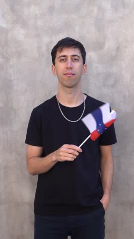 Male adult waving Netherlands Antilles country flag. Vertical slowmo.