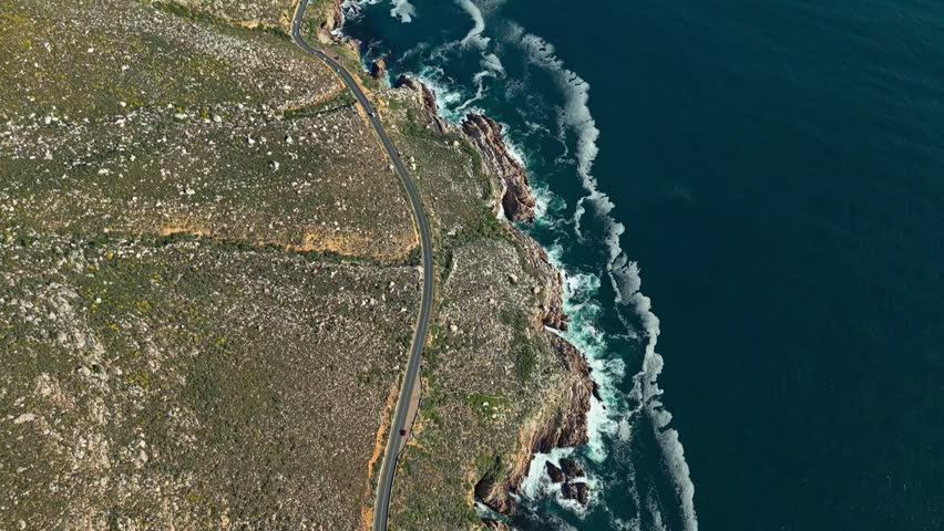 Rugged Atlantic coastline and coastal road near Cape Town, South Africa. Ideal for travel, tourism, nature and scenic landscape concepts, top-down aerial reveal