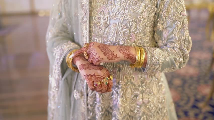 Elegant Asian bride adjusting and admiring her bridal jewelry during wedding preparations. Close-up footage highlighting traditional ornaments, beauty, grace, and cultural wedding traditions.