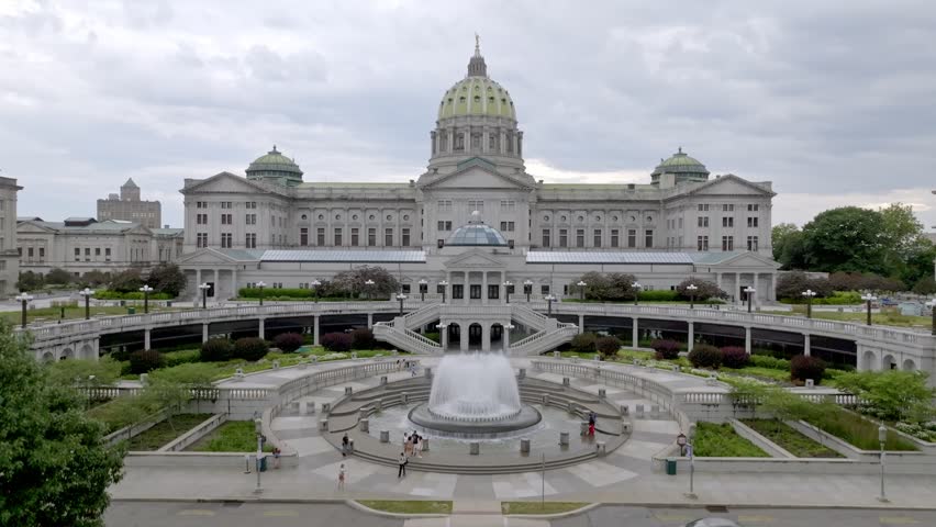 Pennsylvania state capitol building with fountain and drone video moving up.