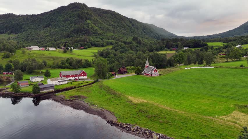 An Aerial view of a hilly rural landscape with river surrounding the medieval Rodven Stave Church at Roedven, near Aandalsnes, Norway.