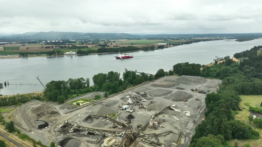 Aerial view of Longview, USA showing quarry, river, and ship passing by.