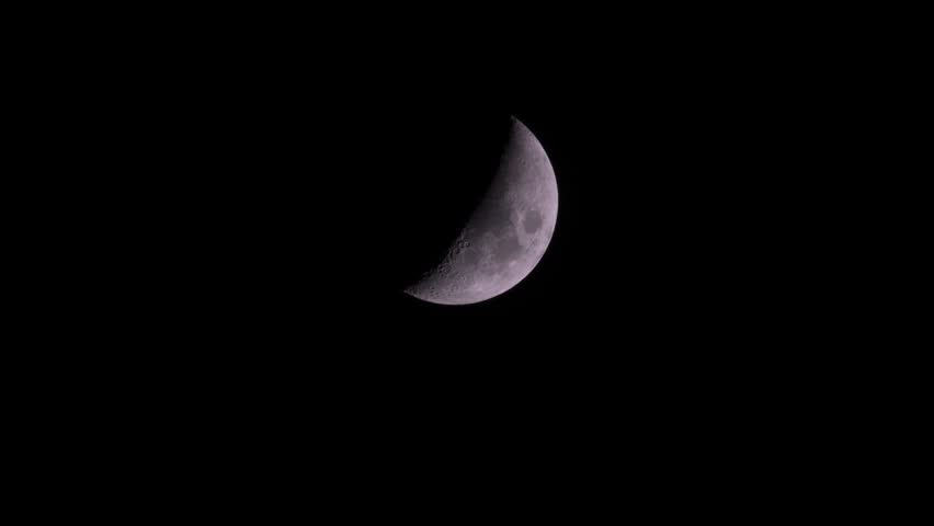 View of the crescent moon glowing against the dark night sky in Algeria.