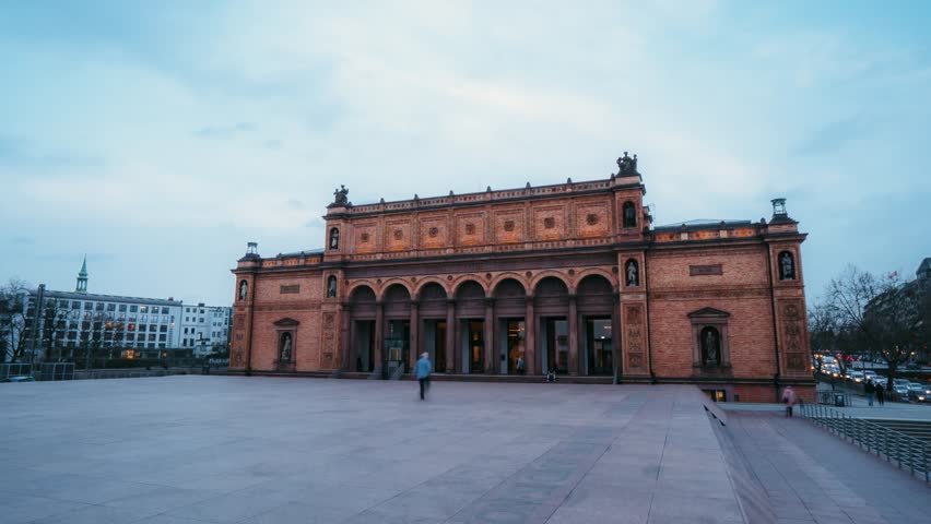 View of the historic brick facade of the Hamburger Kunsthalle museum with its arched entrance and open plaza in Hamburg, Germany.