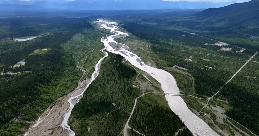 Flying above the branching river spread in the valley. Vast nature landscapes of Alaska.