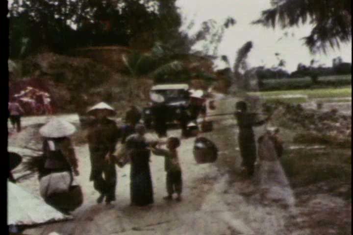 1960s - Soldiers and Vietnamese refugees leave a camp during the Vietnam war