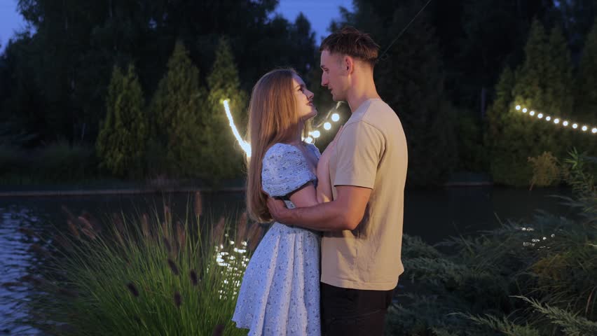 Romantic couple embracing and kissing at night