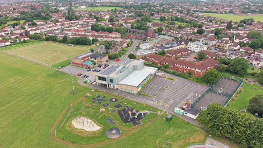 Aerial drone footage of Filton near Bristol, England, showcasing the urban landscape, residential areas, infrastructure, green spaces, and surrounding development