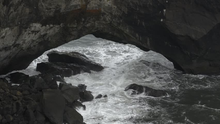 Ocean Waves Crashing Under the Dyrhólaey Sea Arch in Southern Iceland