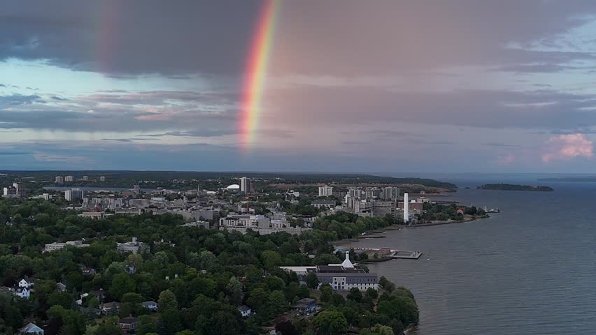 A Rainbow arcs above Kingston City Hall with Lake Ontario and marina in the scenic background