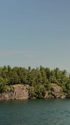 Forested Rocky Cliff Along Calm Waterfront