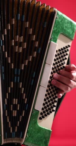 Man playing piano accordion on stage, closeup. Camera moving left