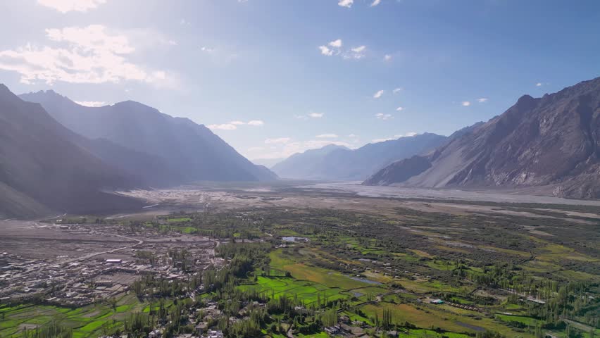 Aerial view of Diskit Monastery nestled within the lush green fields and rugged mountain landscape of the Shyok River valley in Diskit, Ladakh, INDIA.