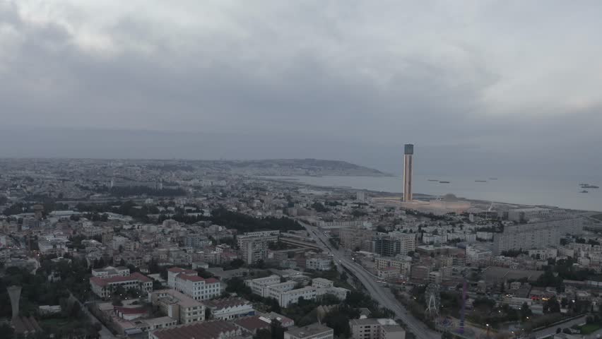 Aerial view of the Great Mosque of Algiers with its prominent minaret overlooking the Mediterranean Sea and the urban landscape of Algiers, Algeria.