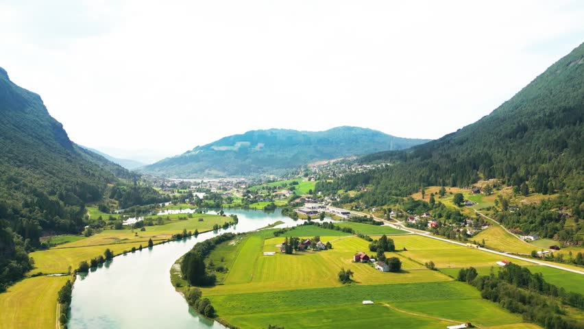 Aerial view of the river flowing through the green valley of Stryn surrounded by mountains in Stryn, Vestland, Norway.