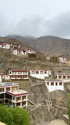 A cinematic city and mountains of Ladakh, India, featuring dramatic cloud formations, colorful rock formations, and the scenic Himalayan landscape. Ideal for travel, adventure, tourism, road journey, and nature-related projects.