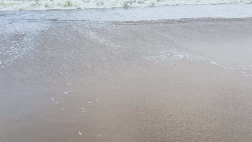 Gentle Sea Waves Washing Over Wet Sandy Beach Shoreline