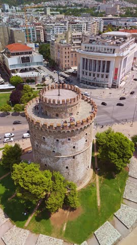 Aerial view of the iconic White Tower standing by the Thermaic Gulf with the city and mountains behind in Thessaloniki, Greece