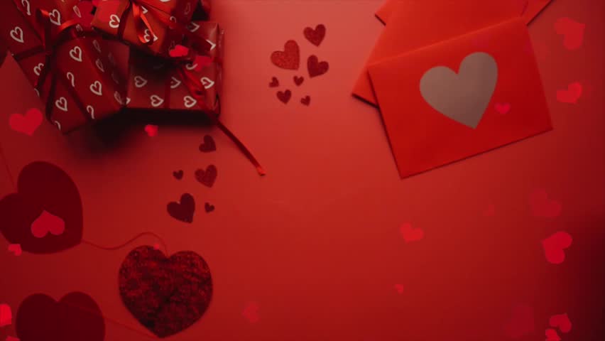Flying Red Hearts Over Valentine Gifts and Heart Decoration on Table
