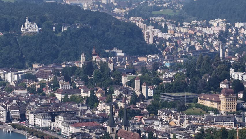 An aerial view of Lucerne, Switzerland showing city skyline, historic towers, and hillside buildings