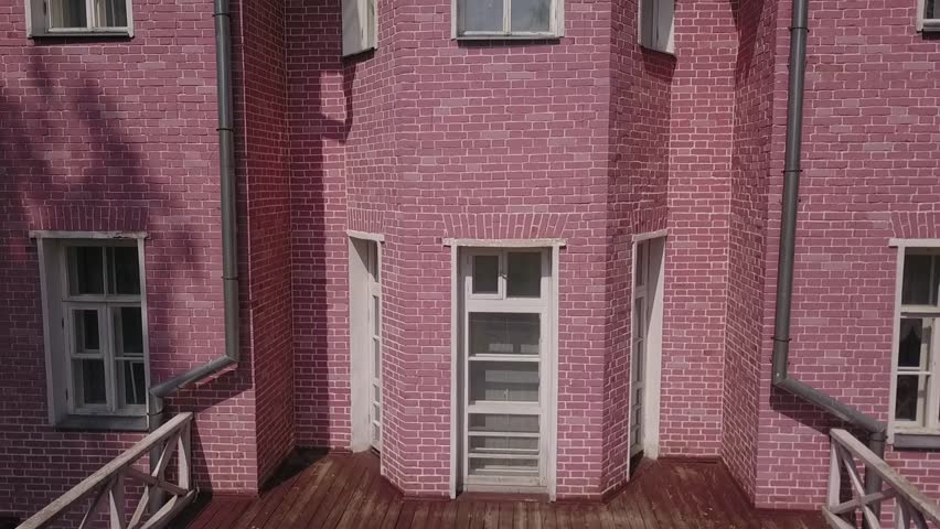 Ascending drone view of pink brick facade