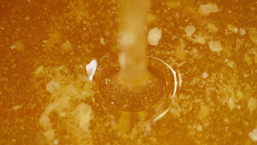 Honey dripping from honeycombs extreme macro. Natural bees, healthy nutrition, gourmet cuisine, beverages, baking, tea, wellness and natural sweeteners.