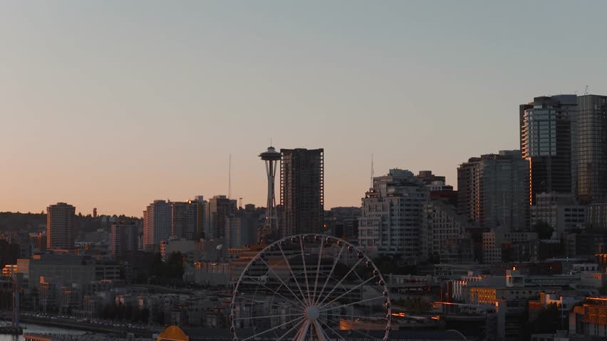 A scenic drone view of Seattle skyline with Space Needle and Ferris wheel at sunset light