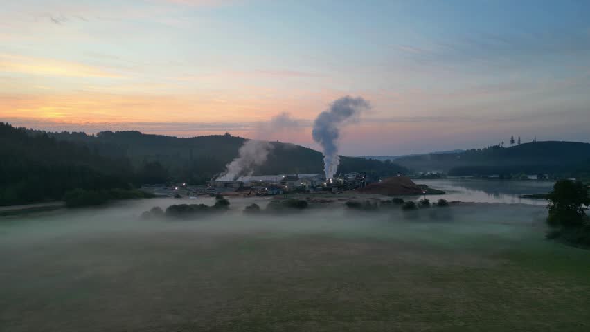 An aerial view of mist over Stimson Lumber mill near Hagg Lake, Oregon with sunset sky on the horizon