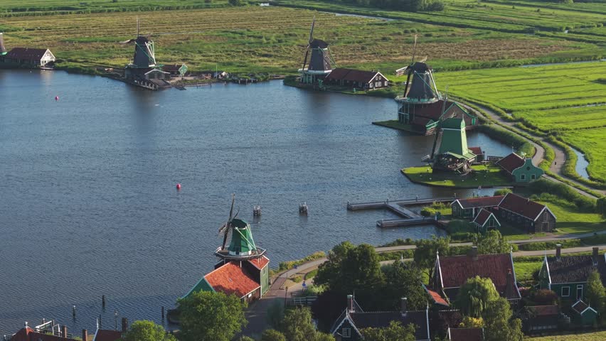 An orbiting aerial view of the historic windmills on the Zaan River in Zaanse Schans village in the Netherlands