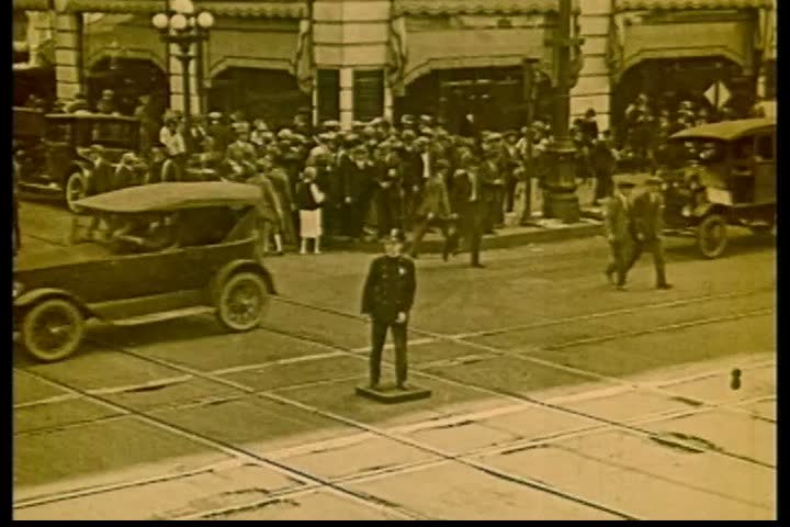 1920s - A room full of people engage in conversation about city life