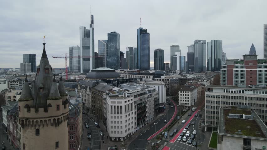 Aerial view of the modern Frankfurt am Main skyline rising behind the historic Eschenheimer Turm, with city streets and urban architecture in Frankfurt am Main, Hessen, Germany.