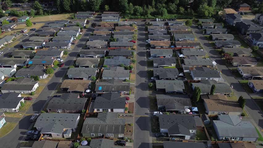 Street networks define compact subdivisions near tree filled tracts situated throughout Kent, WA. rooftops capture afternoon sunlight, emphasizing structural alignment found across neighborhood. USA