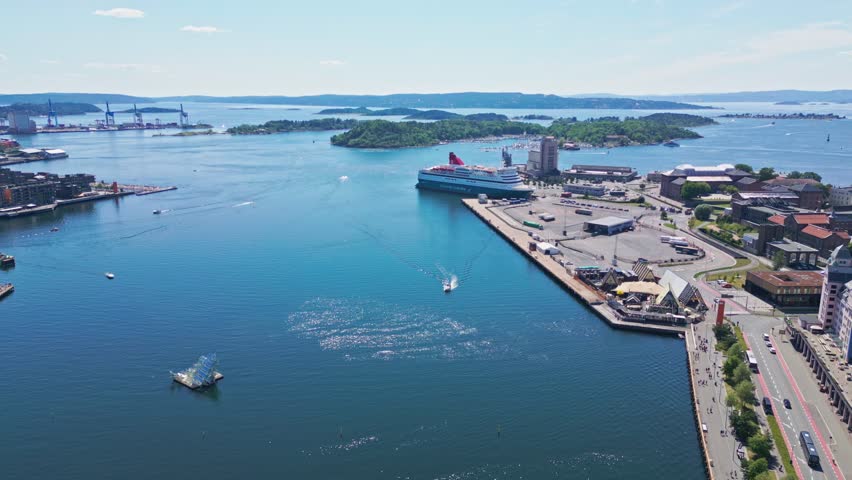 Aerial view of a large cruise ship docked at the port of Oslo with surrounding waterfront buildings and calm blue water in Oslo, Oslo, Norway.