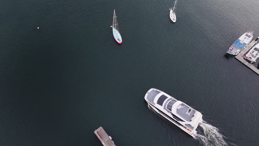 Top down aerial drone footage of boat departing Bellerive Marina at sunrise, Hobart, Tasmania, Australia