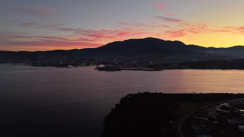 Aerial drone footage of vibrant sunset over the Derwent River and Bellerive, Hobart, Tasmania, Australia