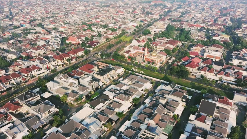 High Angle Drone Footage of Luxury Residential Housing Complex Surrounding a Beautiful Golden Dome Mosque. Surabaya, Indonesia.