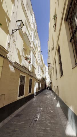 Historic alley with traditional architecture on a sunny day in Cádiz, Andalusia, Spain