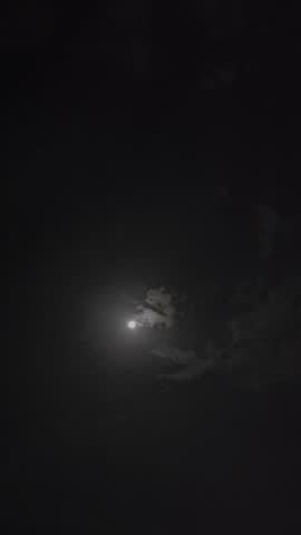 Beautiful bright moon shining through a dramatic dark night sky.