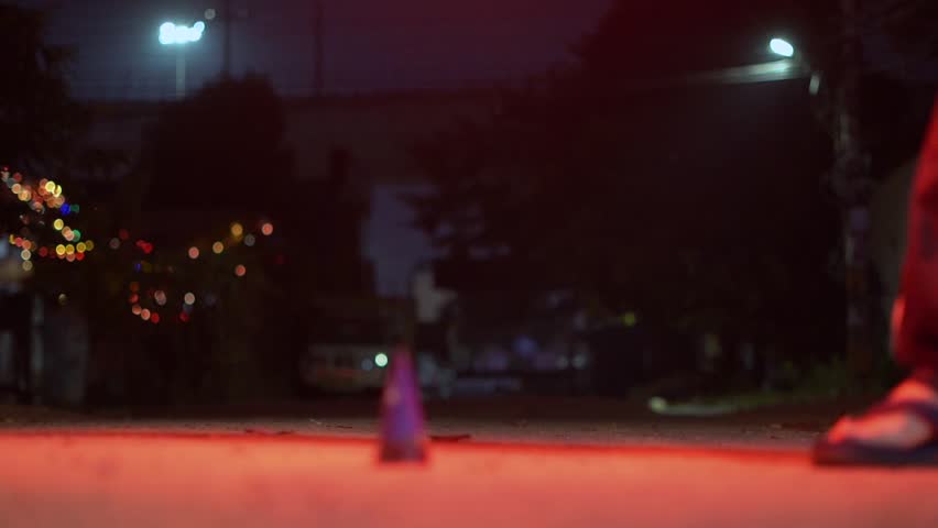 Close-up of a person using a sparkler to light an anar fountain firework during Diwali celebrations at night, with glowing flames and smoke with background of a city street