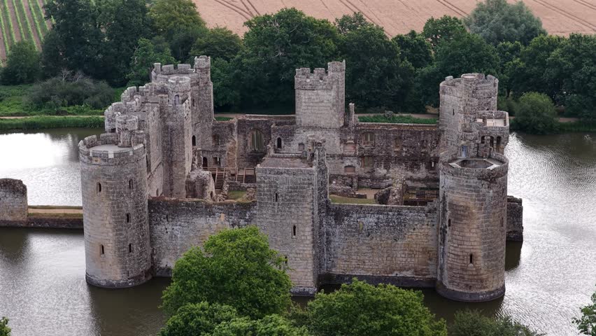 Bodiam Castle towers rise above the water on a summer day