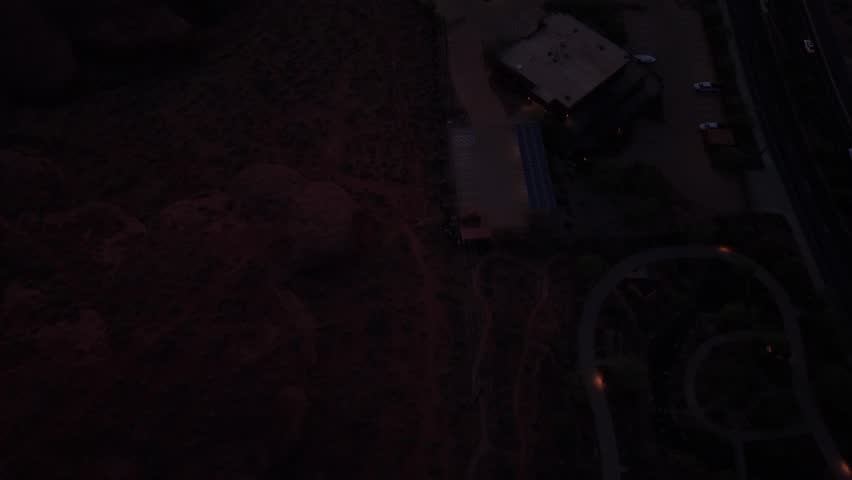 Aerial tilt up from red rocks to St George city at sunrise in Utah