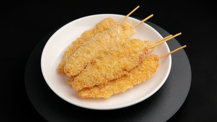 Fried chicken bites on a skewer or Popcorn chicken on a stick in white plate.