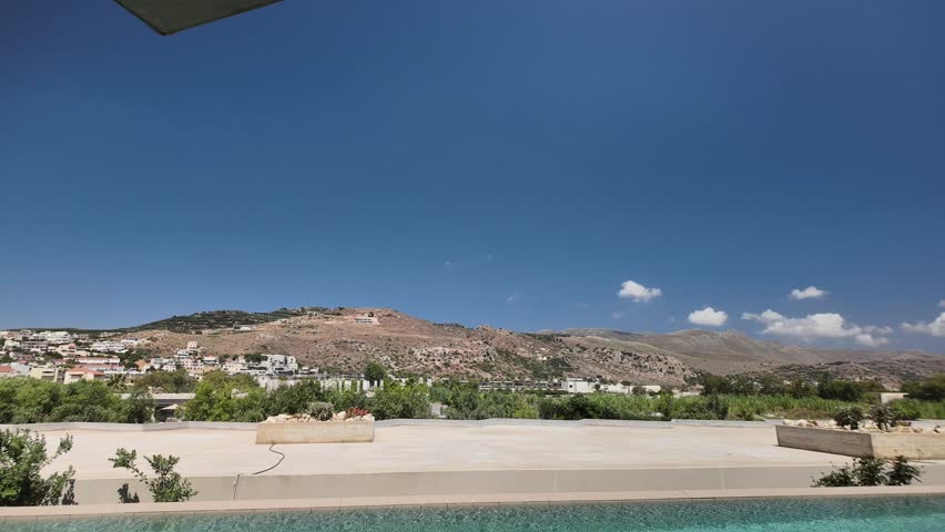 Beautiful view of Mediterranean mountains from resort terrace with swimming pool in time lapse. Crete. Greece.
