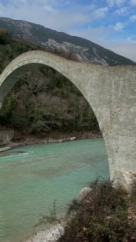 A vertical footage of the historic Plaka Arch Bridge, spans the Arachthos River in the Epirus region of Greece