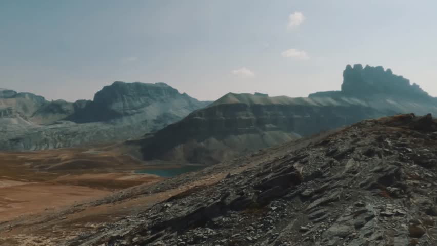 A view from the summit of Helen Lake Trail in Banff National Park, Alberta. Rugged alpine terrain, golden meadows, and peaks of the Canadian Rockies