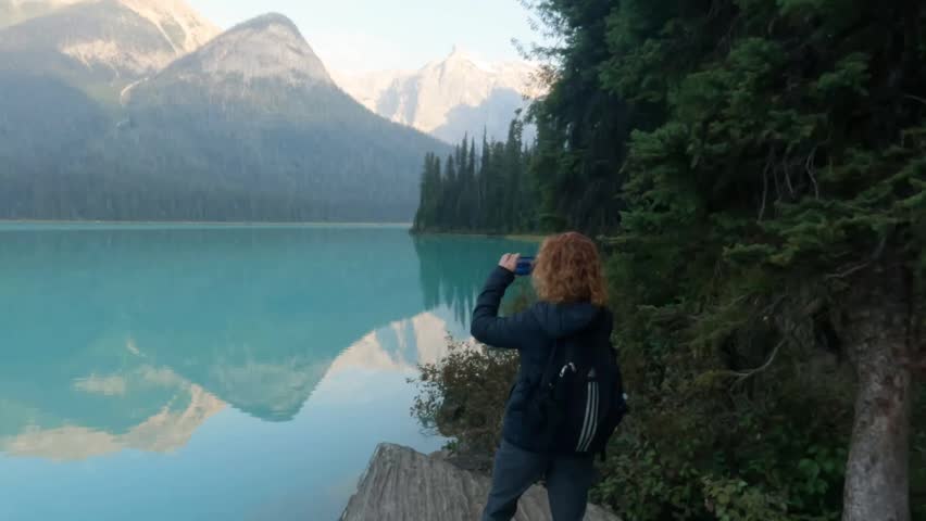 A hiker stands at the Emerald Lake