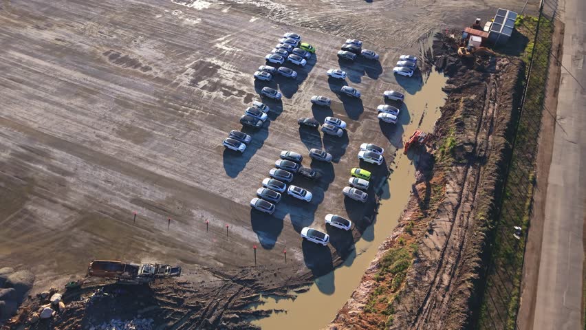 Aerial view of cars parked in a muddy new lot