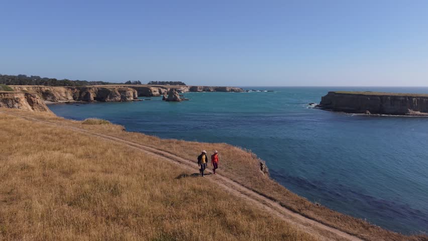 A man and woman hike together along the cliffs on the Point Arena trail near the lighthouse south of Mendocino.