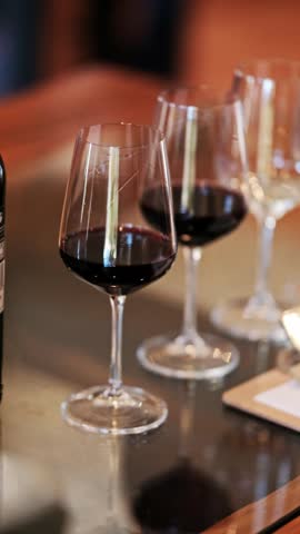 Vertical footage of red wine glasses at a wine tasting