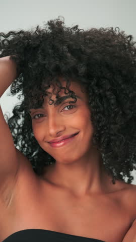 Vertical portrait of young smiling model with curly hair in afro style and bright makeup. Slow Motion, Close Up.